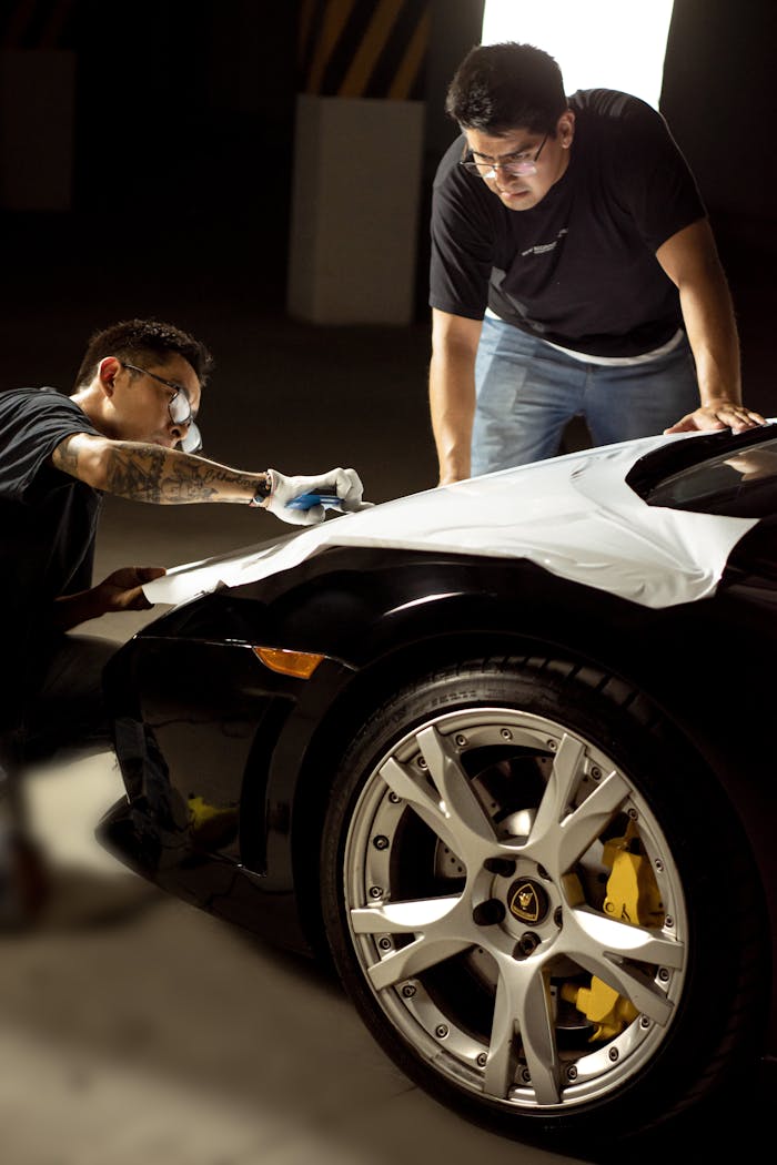 Two Men Working on a Black Lamborghini Car